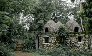Discover serene stone meditation huts nestled in a lush jungle setting, offering peace and tranquility.